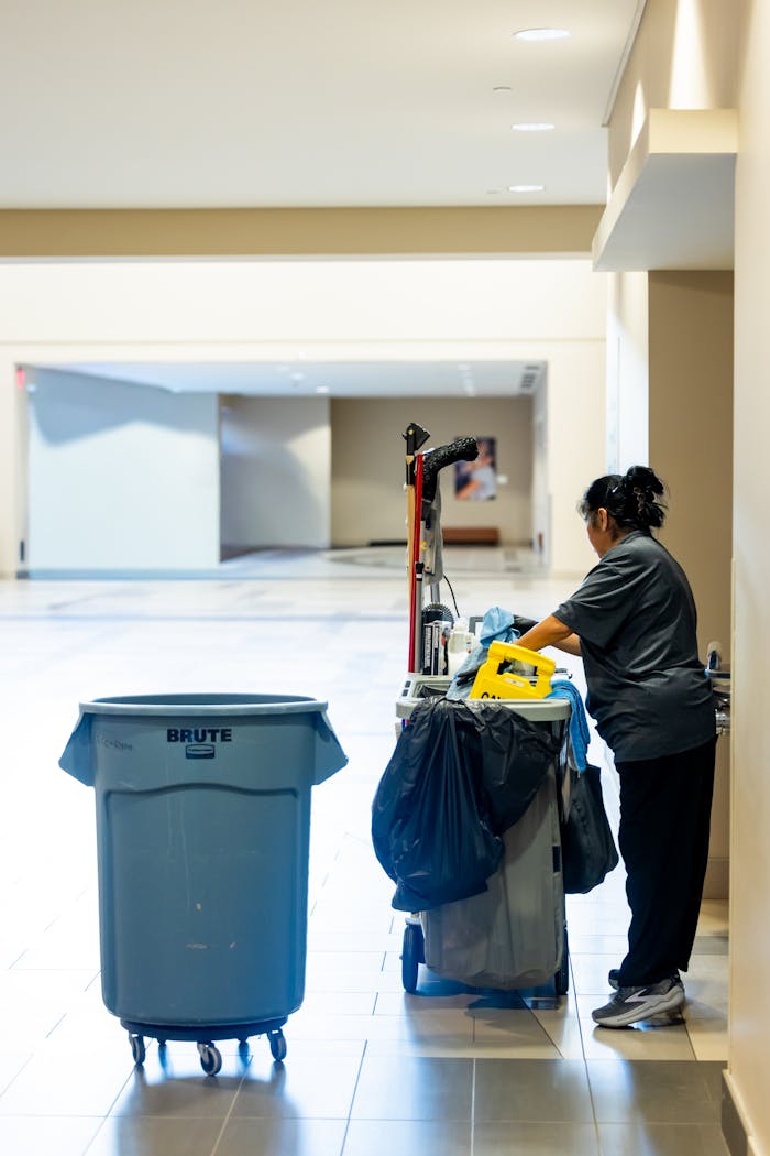 hero-img A janitorial worker pushes a cleaning cart in a spacious indoor hallway.